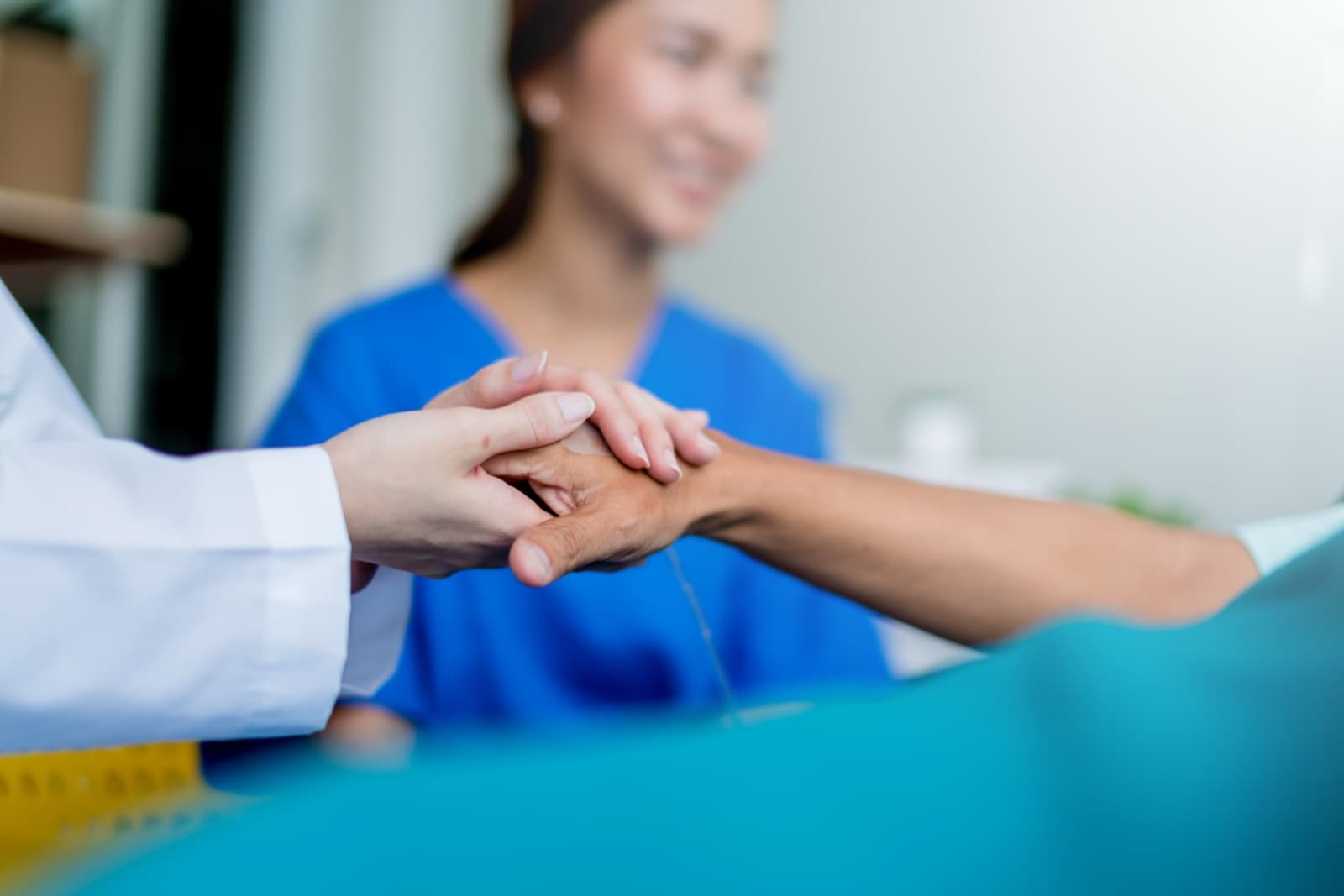 Läkare håller en patients hand under en konsultation
